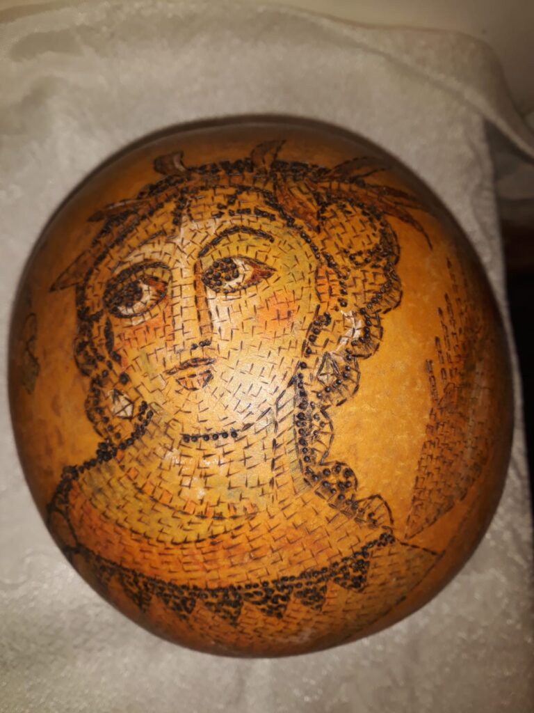 דלועי נוי קצת עלי – הגענו לנוב לפני כ- 31 שנים. אנו עוסקים במגוון תחומים, ביניהם בחקלאות אורגנית, ואני עוסקת באומנות בדלועי נוי ובציורי קיר. המפגש הראשון שלי עם הדלועים – קבלתי זרעים לא מוכרים מחברה, זרעתי ברחבי הגינה, ונדהמתי לגלות ירק חדש ומעניין, אשר השתרע על הקרקע וגם טיפס על העצים. אחרי ניסיון וטעייה, הגעתי לאורך השנים לרמה מקצועית של אומנות בדלועי הנוי, תחום אומנות מגוון ומדהים. מה הם דלועי נוי? – פירות ממשפחת הדלועיים, בעלי קליפה קשה וקלה. איפה הם גדלים? – אצלנו בחצר, מהאביב ועד לסתיו מתי התחלנו לגדל אותם? – לפני קרוב לעשרים שנה האם הדלועים אכילים? – רובם אכילים, מיעוטם מרים האם יש סוגים שונים של דלועי נוי? – כן, תלוי בזרעים האם אפשר להשפיע על צורתם? – כן, בזמן הגידול למה יש עליהם כתמים? – העובש שגדל על הקליפה גורם ליצירת כתמים. האם הדלועים שבירים? – כן! הם יכולים להיסדק ולהישבר. לא להפיל אותם! מה אפשר לעשות איתם? – כל טכניקת עבודה עם עץ, מתאימה לדלועים. מה אורך חייהם? – לנצח, כל עוד הם בתוך הבית ולא חשופים לפגעי מזג האוויר. איפה מגדלים דלועים מלבד בנוב? – יש כמה בארץ, והרבה במערב ובמזרח. יש גם סדנאות? – כן, אצלי בסטודיו, אחרי תיאום מראש. 0524425578 עיצוב דלועי נוי