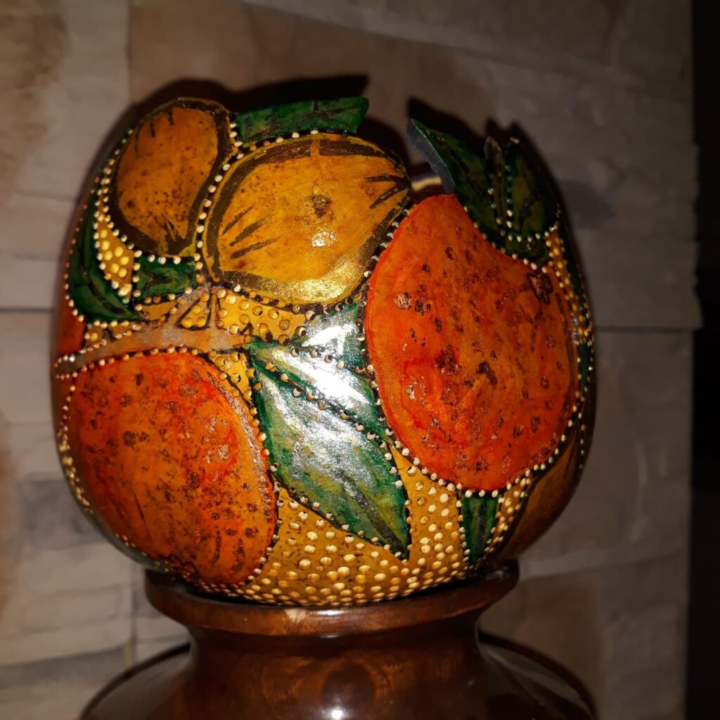 דלועי נוי קצת עלי – הגענו לנוב לפני כ- 31 שנים. אנו עוסקים במגוון תחומים, ביניהם בחקלאות אורגנית, ואני עוסקת באומנות בדלועי נוי ובציורי קיר. המפגש הראשון שלי עם הדלועים – קבלתי זרעים לא מוכרים מחברה, זרעתי ברחבי הגינה, ונדהמתי לגלות ירק חדש ומעניין, אשר השתרע על הקרקע וגם טיפס על העצים. אחרי ניסיון וטעייה, הגעתי לאורך השנים לרמה מקצועית של אומנות בדלועי הנוי, תחום אומנות מגוון ומדהים. מה הם דלועי נוי? – פירות ממשפחת הדלועיים, בעלי קליפה קשה וקלה. איפה הם גדלים? – אצלנו בחצר, מהאביב ועד לסתיו מתי התחלנו לגדל אותם? – לפני קרוב לעשרים שנה האם הדלועים אכילים? – רובם אכילים, מיעוטם מרים האם יש סוגים שונים של דלועי נוי? – כן, תלוי בזרעים האם אפשר להשפיע על צורתם? – כן, בזמן הגידול למה יש עליהם כתמים? – העובש שגדל על הקליפה גורם ליצירת כתמים. האם הדלועים שבירים? – כן! הם יכולים להיסדק ולהישבר. לא להפיל אותם! מה אפשר לעשות איתם? – כל טכניקת עבודה עם עץ, מתאימה לדלועים. מה אורך חייהם? – לנצח, כל עוד הם בתוך הבית ולא חשופים לפגעי מזג האוויר. איפה מגדלים דלועים מלבד בנוב? – יש כמה בארץ, והרבה במערב ובמזרח. יש גם סדנאות? – כן, אצלי בסטודיו, אחרי תיאום מראש. 0524425578 עיצוב דלועי נוי