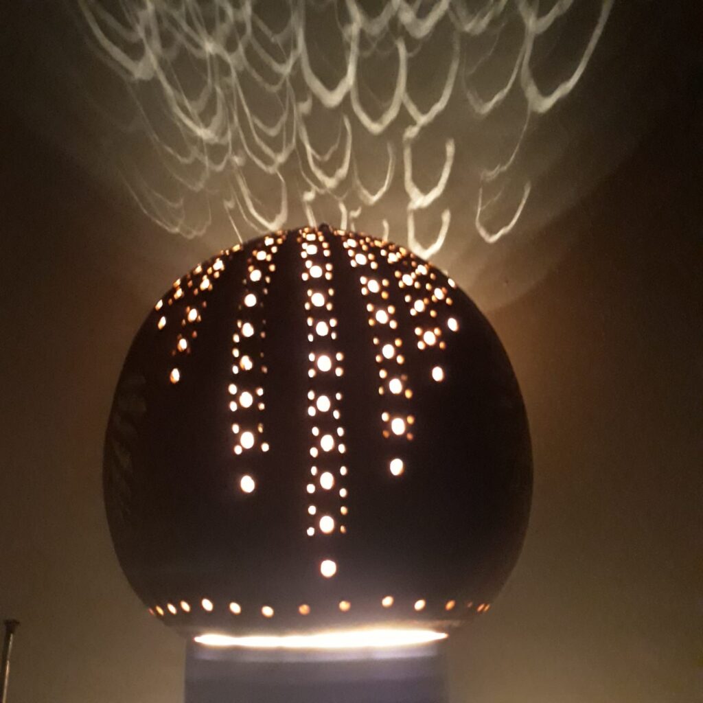 דלועי נוי קצת עלי – הגענו לנוב לפני כ- 31 שנים. אנו עוסקים במגוון תחומים, ביניהם בחקלאות אורגנית, ואני עוסקת באומנות בדלועי נוי ובציורי קיר. המפגש הראשון שלי עם הדלועים – קבלתי זרעים לא מוכרים מחברה, זרעתי ברחבי הגינה, ונדהמתי לגלות ירק חדש ומעניין, אשר השתרע על הקרקע וגם טיפס על העצים. אחרי ניסיון וטעייה, הגעתי לאורך השנים לרמה מקצועית של אומנות בדלועי הנוי, תחום אומנות מגוון ומדהים. מה הם דלועי נוי? – פירות ממשפחת הדלועיים, בעלי קליפה קשה וקלה. איפה הם גדלים? – אצלנו בחצר, מהאביב ועד לסתיו מתי התחלנו לגדל אותם? – לפני קרוב לעשרים שנה האם הדלועים אכילים? – רובם אכילים, מיעוטם מרים האם יש סוגים שונים של דלועי נוי? – כן, תלוי בזרעים האם אפשר להשפיע על צורתם? – כן, בזמן הגידול למה יש עליהם כתמים? – העובש שגדל על הקליפה גורם ליצירת כתמים. האם הדלועים שבירים? – כן! הם יכולים להיסדק ולהישבר. לא להפיל אותם! מה אפשר לעשות איתם? – כל טכניקת עבודה עם עץ, מתאימה לדלועים. מה אורך חייהם? – לנצח, כל עוד הם בתוך הבית ולא חשופים לפגעי מזג האוויר. איפה מגדלים דלועים מלבד בנוב? – יש כמה בארץ, והרבה במערב ובמזרח. יש גם סדנאות? – כן, אצלי בסטודיו, אחרי תיאום מראש. 0524425578 עיצוב דלועי נוי