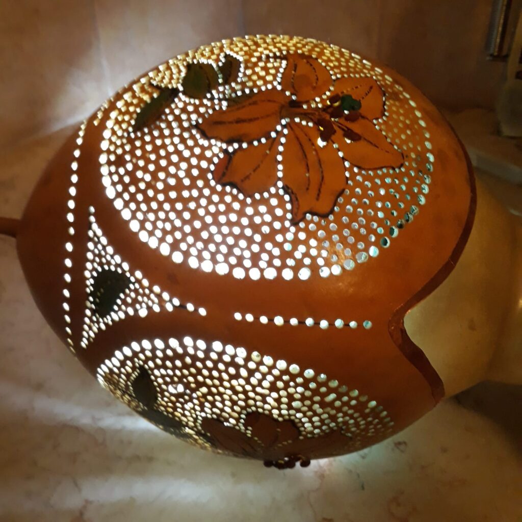 דלועי נוי קצת עלי – הגענו לנוב לפני כ- 31 שנים. אנו עוסקים במגוון תחומים, ביניהם בחקלאות אורגנית, ואני עוסקת באומנות בדלועי נוי ובציורי קיר. המפגש הראשון שלי עם הדלועים – קבלתי זרעים לא מוכרים מחברה, זרעתי ברחבי הגינה, ונדהמתי לגלות ירק חדש ומעניין, אשר השתרע על הקרקע וגם טיפס על העצים. אחרי ניסיון וטעייה, הגעתי לאורך השנים לרמה מקצועית של אומנות בדלועי הנוי, תחום אומנות מגוון ומדהים. מה הם דלועי נוי? – פירות ממשפחת הדלועיים, בעלי קליפה קשה וקלה. איפה הם גדלים? – אצלנו בחצר, מהאביב ועד לסתיו מתי התחלנו לגדל אותם? – לפני קרוב לעשרים שנה האם הדלועים אכילים? – רובם אכילים, מיעוטם מרים האם יש סוגים שונים של דלועי נוי? – כן, תלוי בזרעים האם אפשר להשפיע על צורתם? – כן, בזמן הגידול למה יש עליהם כתמים? – העובש שגדל על הקליפה גורם ליצירת כתמים. האם הדלועים שבירים? – כן! הם יכולים להיסדק ולהישבר. לא להפיל אותם! מה אפשר לעשות איתם? – כל טכניקת עבודה עם עץ, מתאימה לדלועים. מה אורך חייהם? – לנצח, כל עוד הם בתוך הבית ולא חשופים לפגעי מזג האוויר. איפה מגדלים דלועים מלבד בנוב? – יש כמה בארץ, והרבה במערב ובמזרח. יש גם סדנאות? – כן, אצלי בסטודיו, אחרי תיאום מראש. 0524425578 עיצוב דלועי נוי